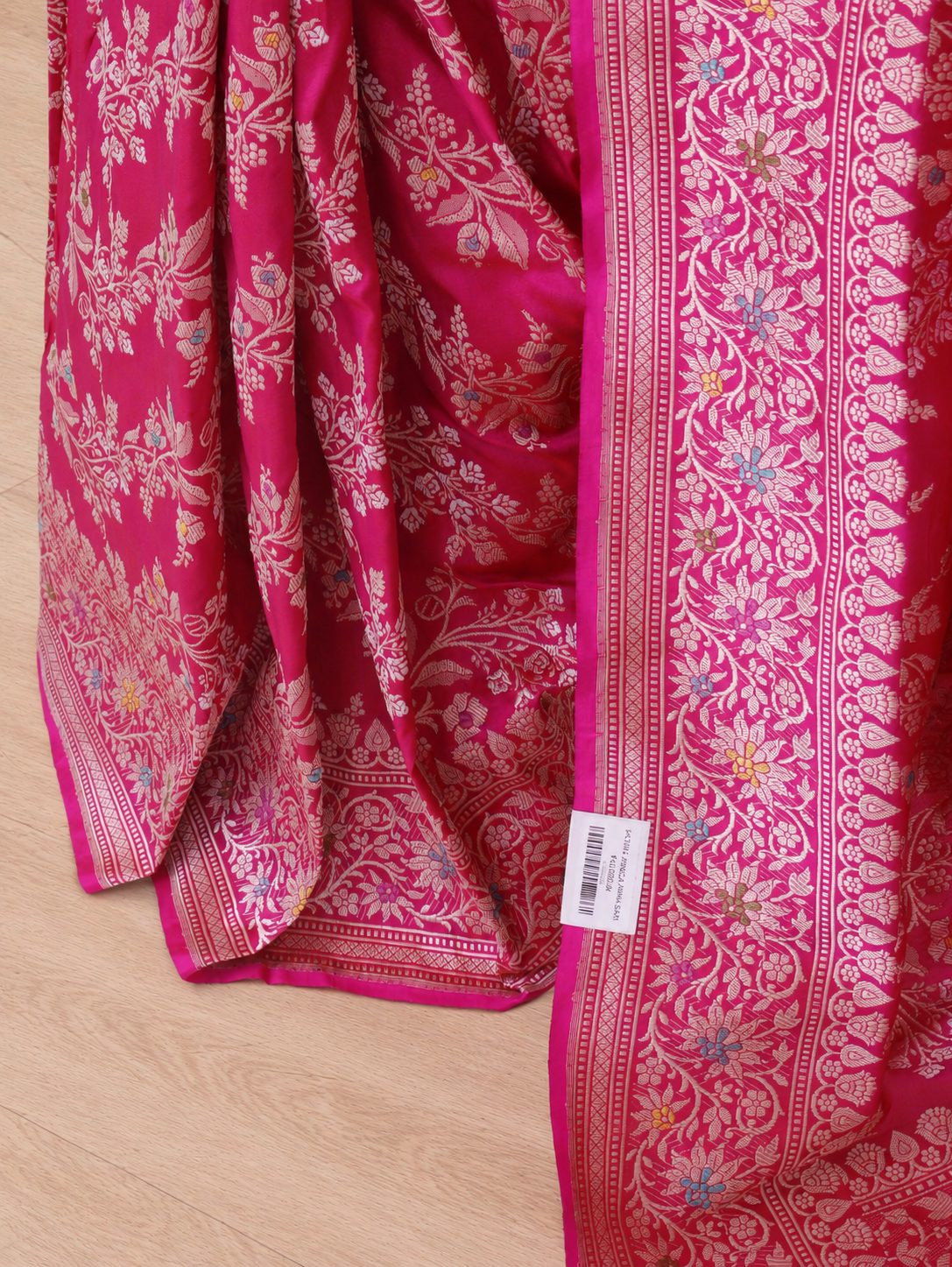 Vibrant rani pink with light gold-toned zari and multicoloured floral accents. Katan Silk Banarasi saree pallu detail