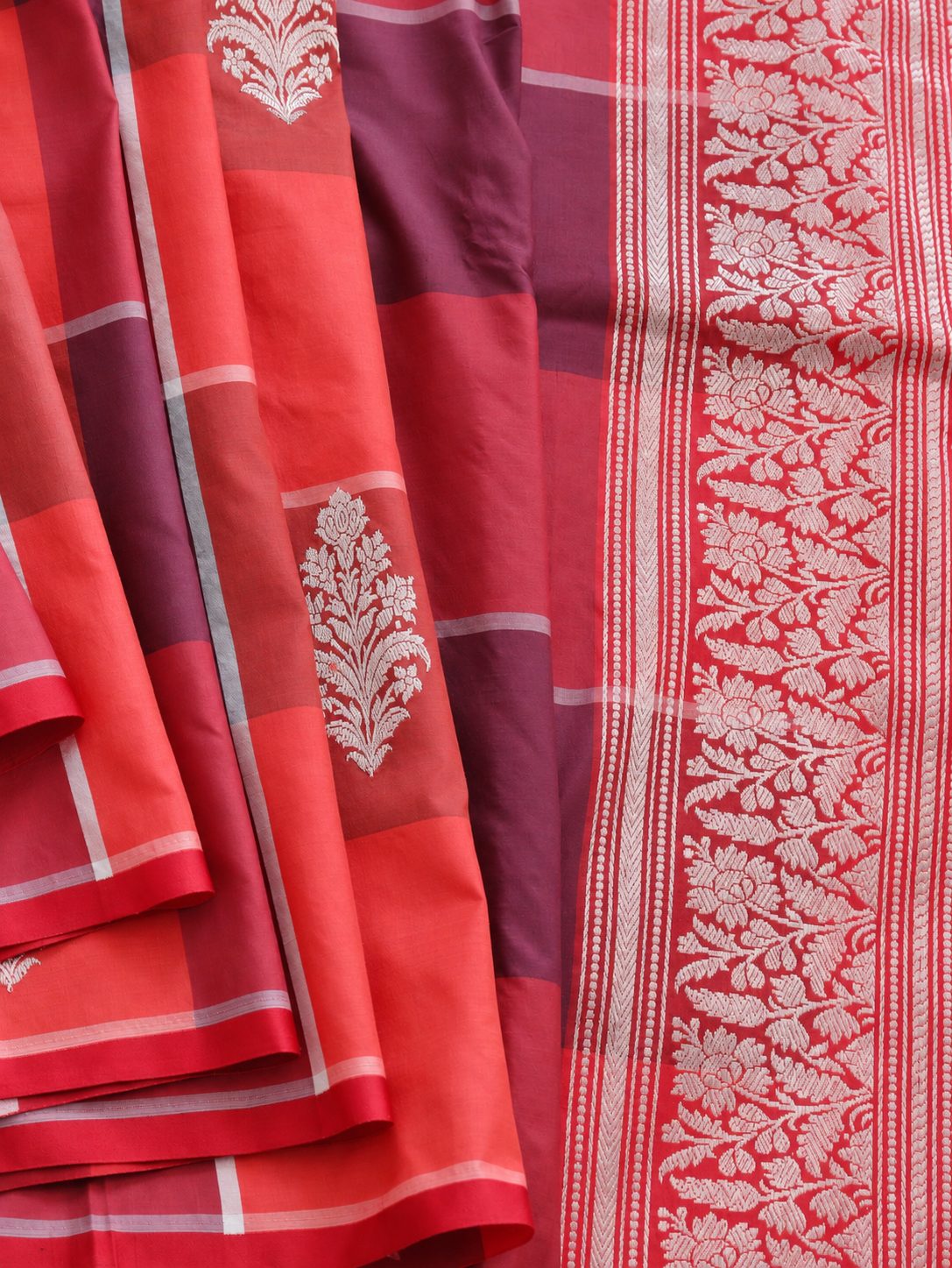 Vibrant coral red and deep plum checks, highlighted with silver-toned woven detailing Katan Silk Banarasi saree front drape view