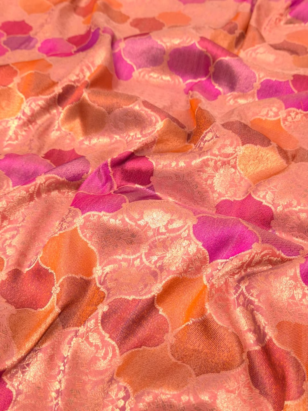 A soft peach and rose-gold base with pink, purple, orange and muted brown accents Mulbari silk Banarasi saree border closeup