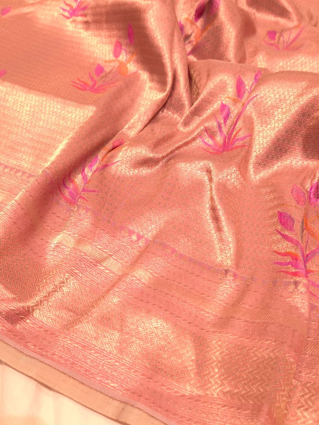 A soft peach and rose-gold base with pink, purple, orange accents Mulbari silk Banarasi saree border closeup