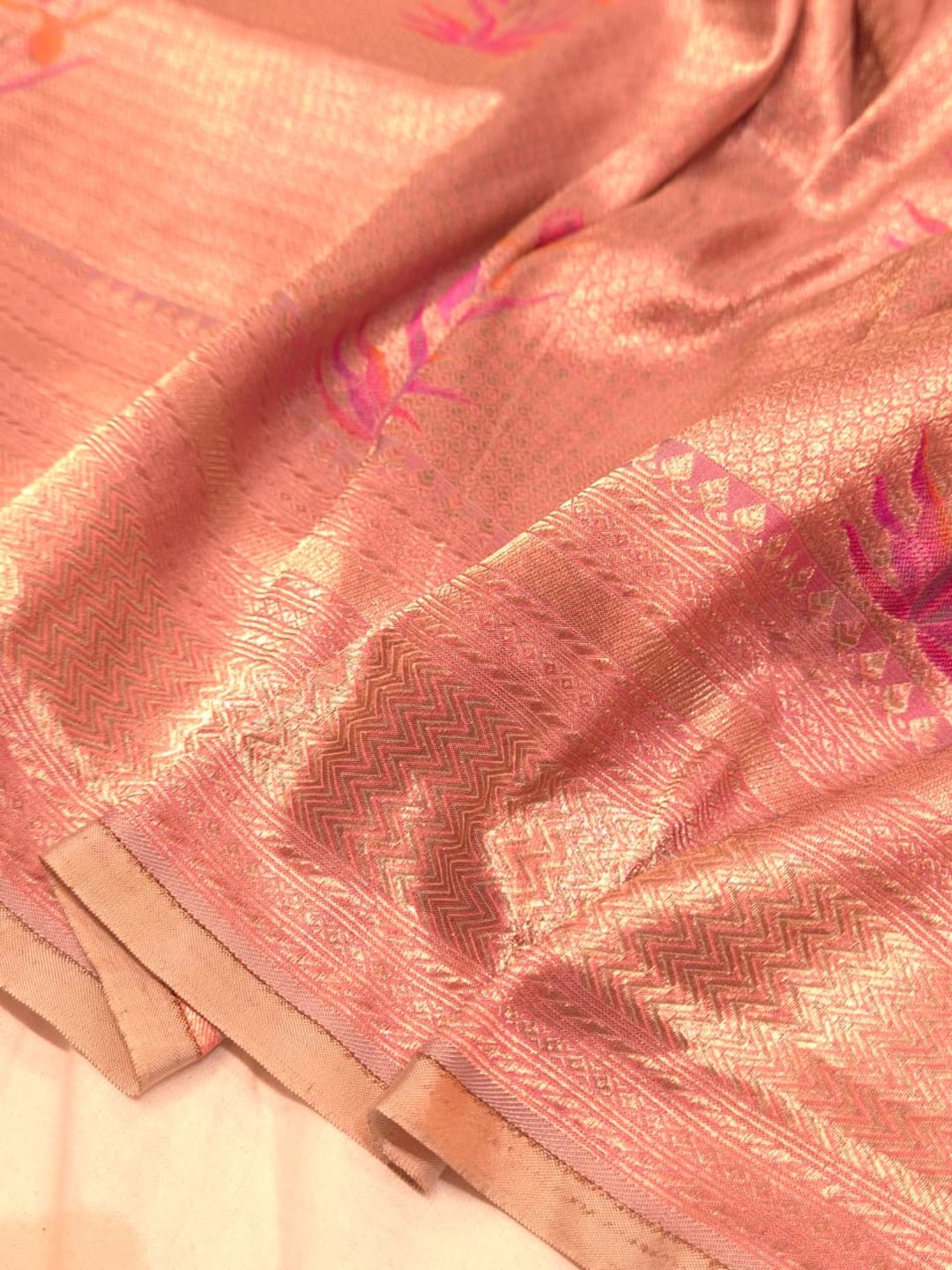 A soft peach and rose-gold base with pink, purple, orange accents Mulbari silk Banarasi saree texture detail