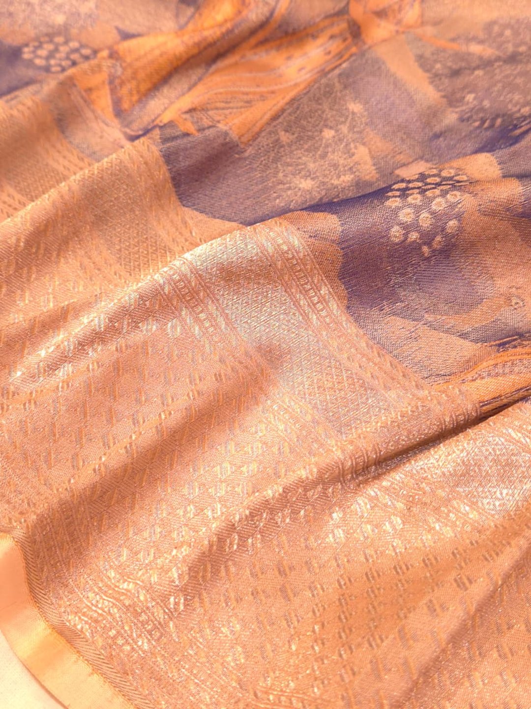 A muted lavender-grey base with peach, orange and gold-toned Mulbari Silk Banarasi saree border closeup