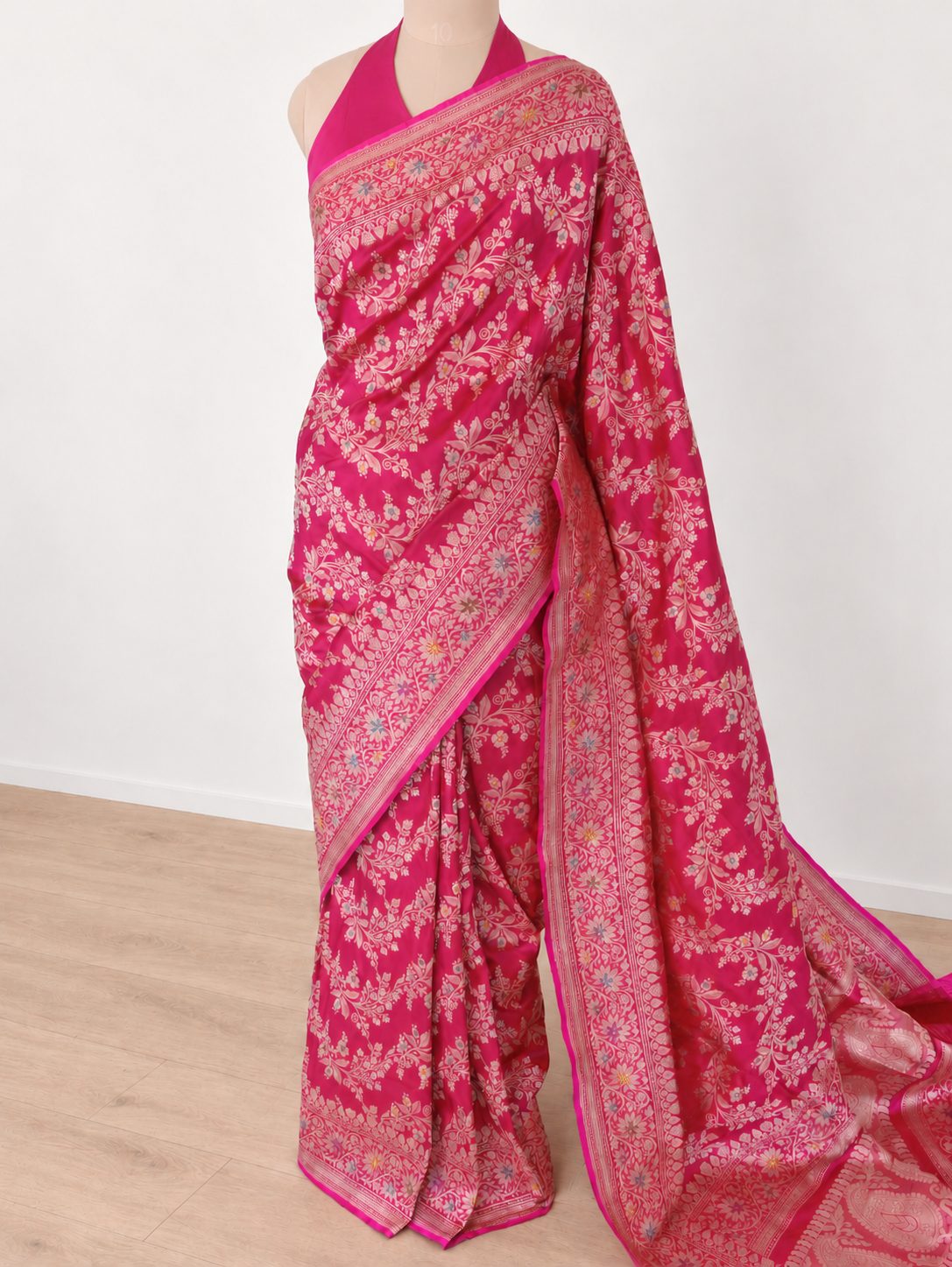 Vibrant rani pink with light gold-toned zari and multicoloured floral accents. Katan Silk Banarasi saree border closeup
