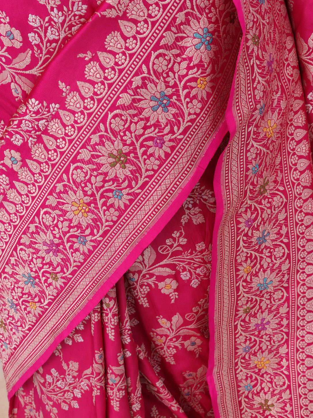 Vibrant rani pink with light gold-toned zari and multicoloured floral accents. Katan Silk Banarasi saree blouse piece