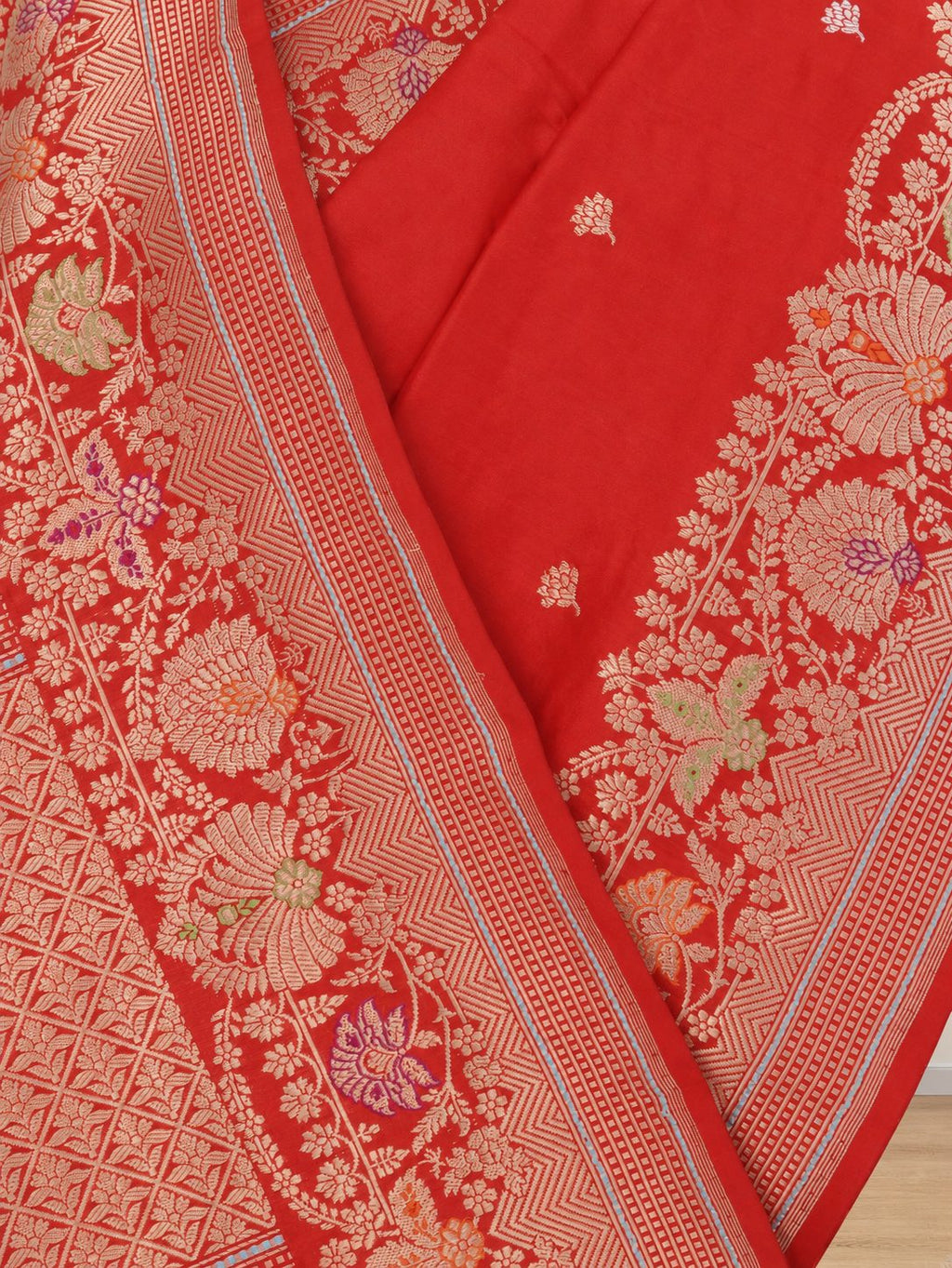 Vibrant vermilion red with gold-toned zari and purple, green and orange accents Katan Silk Banarasi saree border closeup