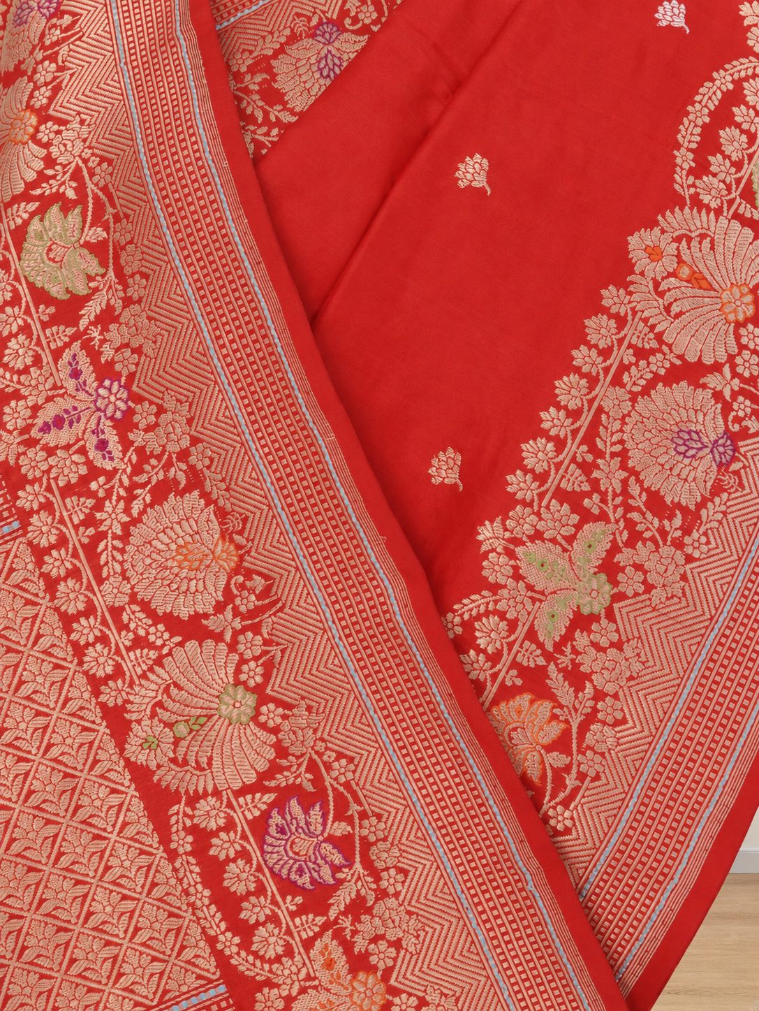 Vibrant vermilion red with gold-toned zari and purple, green and orange accents Katan Silk Banarasi saree border closeup