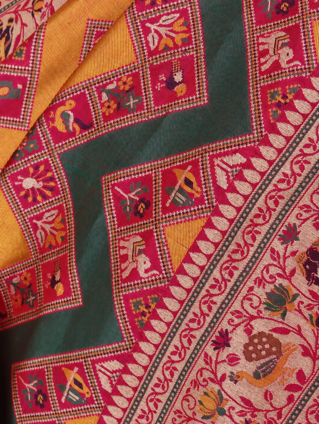 Mustard yellow and deep green, accented with rani pink, red edging and gold toned zari Katan Silk Banarasi saree front drape view