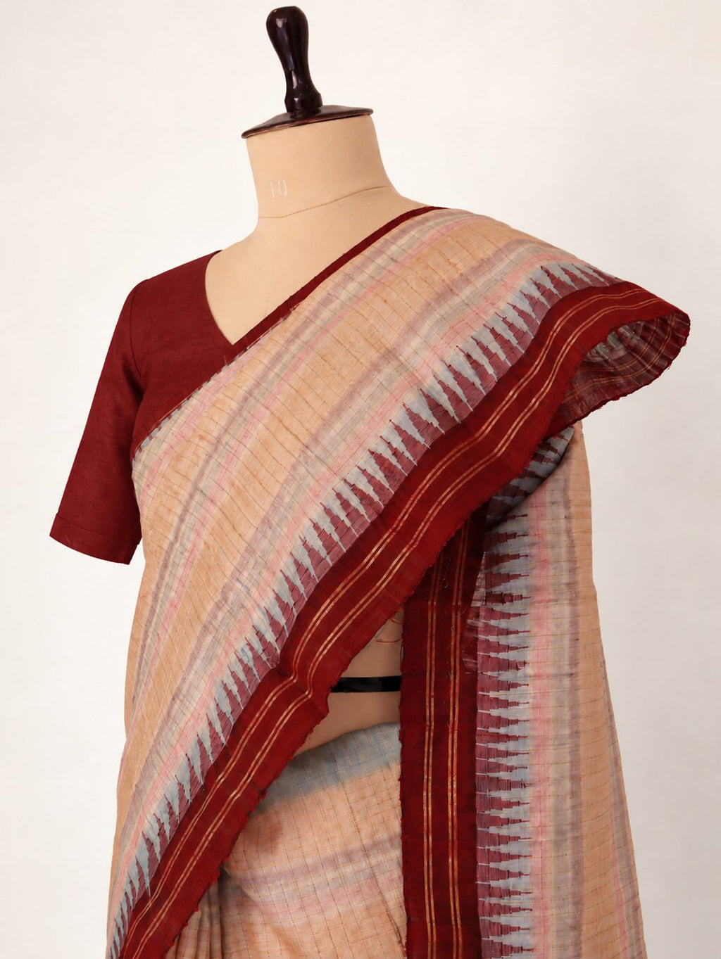 Soft peach-beige with pastel pink and powder-blue accents, contrasted by a deep maroon border Raw Silk Banarasi saree front drape view
