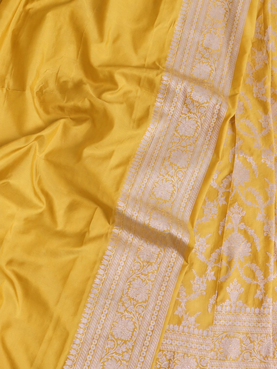 Rich haldi yellow with silver-toned woven detailing Katan Silk Banarasi saree border closeup