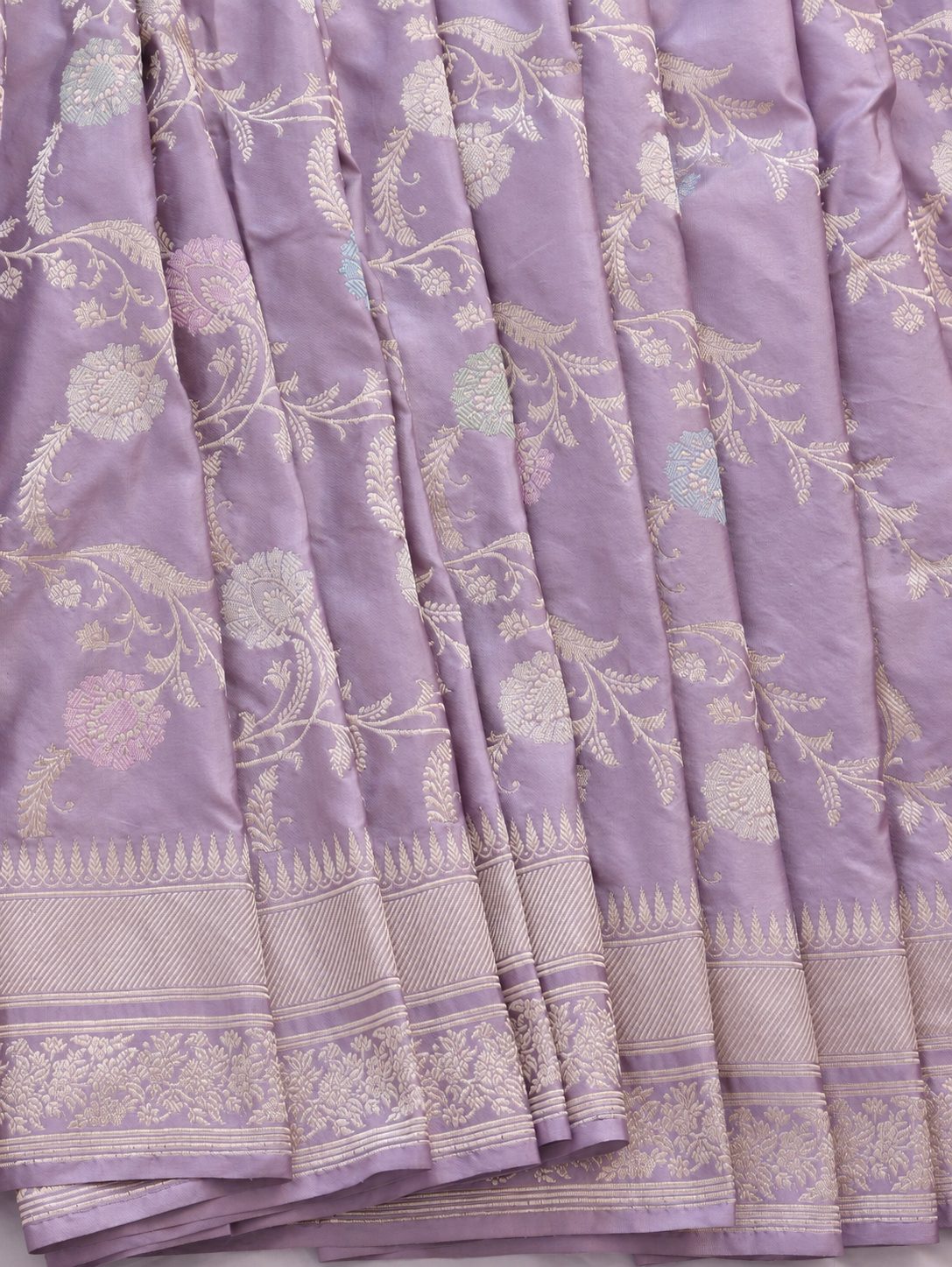 Soft lavender with pale gold zari and pastel pink, blue and mint-green floral accents Katan Silk Banarasi saree texture detail