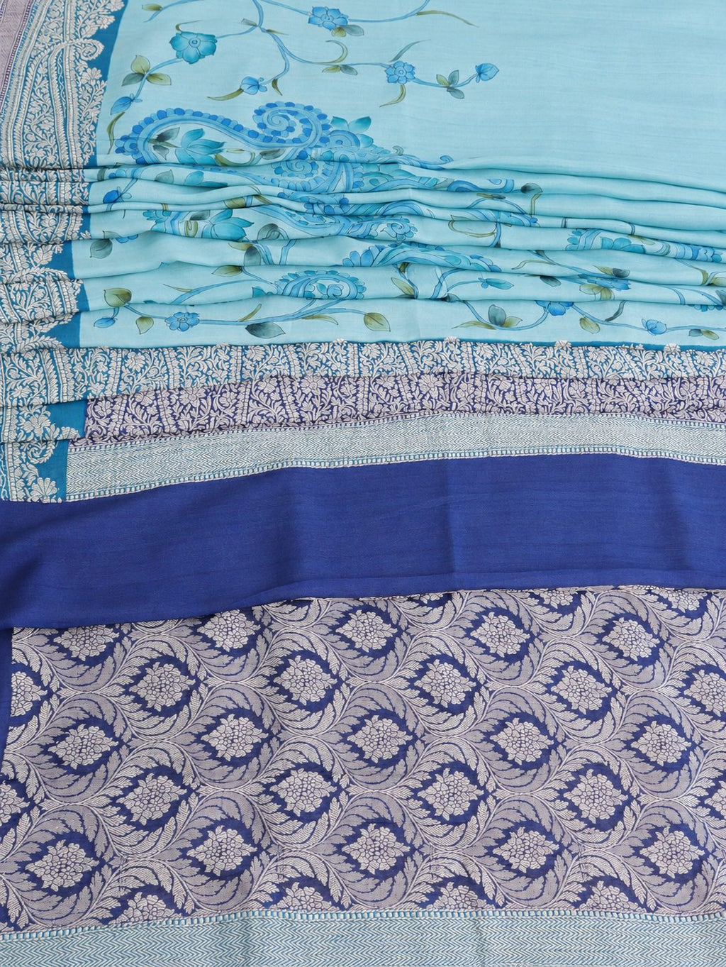 Soft aqua blue body with a contrasting royal blue pallu, blue floral detailing and touches of green Tussar Silk Banarasi saree texture detail