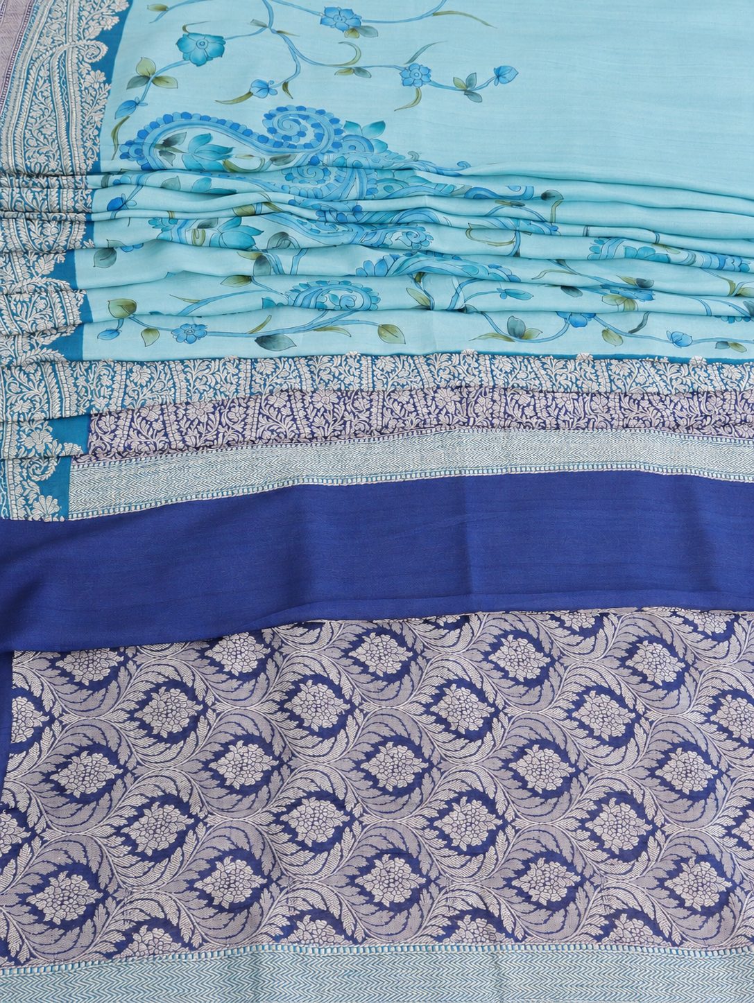 Soft aqua blue body with a contrasting royal blue pallu, blue floral detailing and touches of green Tussar Silk Banarasi saree texture detail