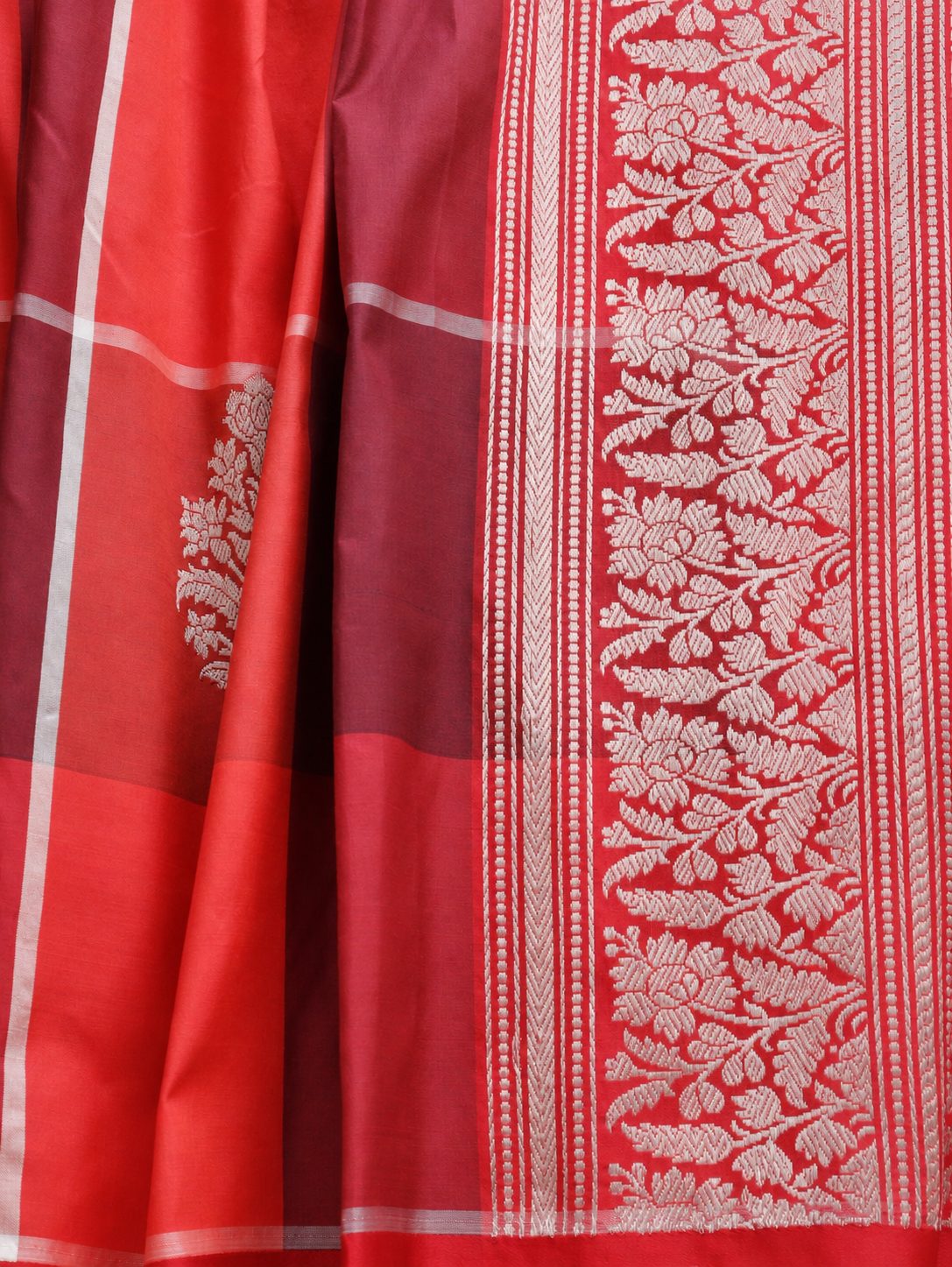 Vibrant coral red and deep plum checks, highlighted with silver-toned woven detailing Katan Silk Banarasi saree border closeup