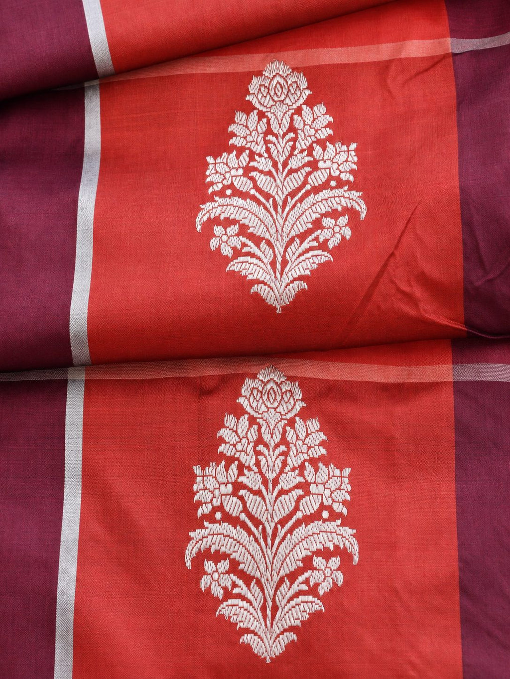 Vibrant coral red and deep plum checks, highlighted with silver-toned woven detailing Katan Silk Banarasi saree pallu detail