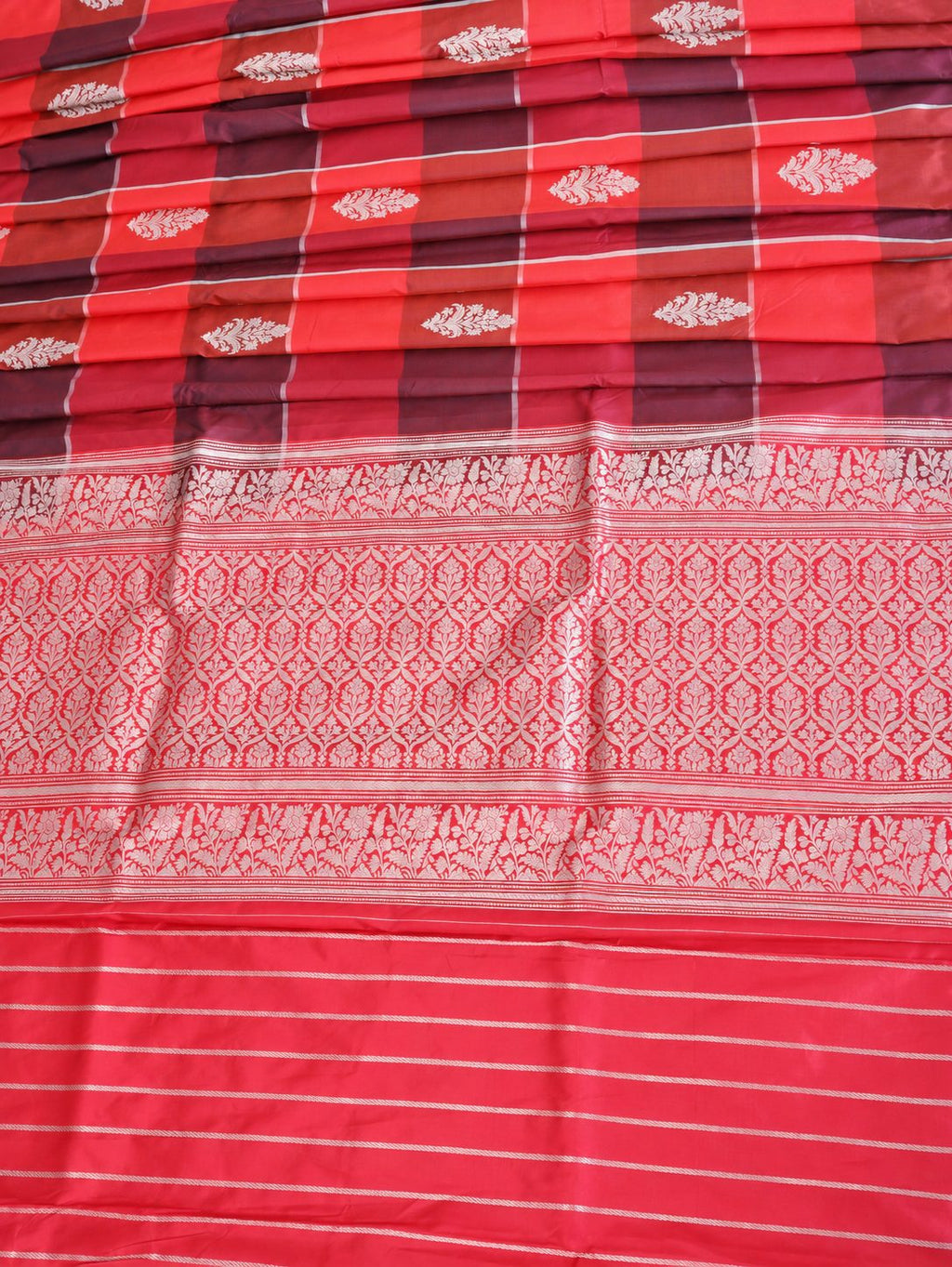 Vibrant coral red and deep plum checks, highlighted with silver-toned woven detailing Katan Silk Banarasi saree texture detail