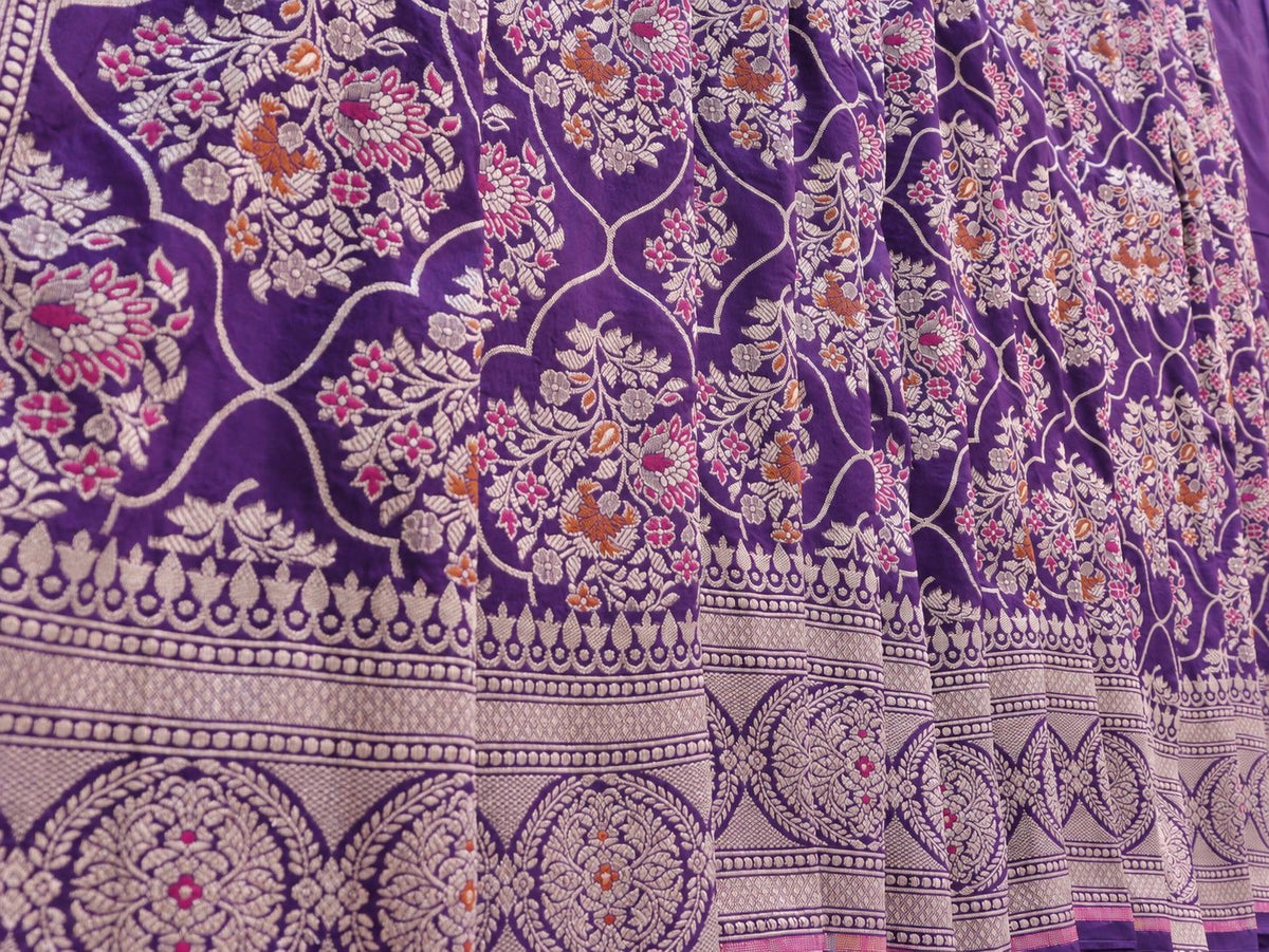 Rich royal purple with pale gold toned zari and vibrant pink and rust-orange floral accents Katan Silk Banarasi saree zari work detail