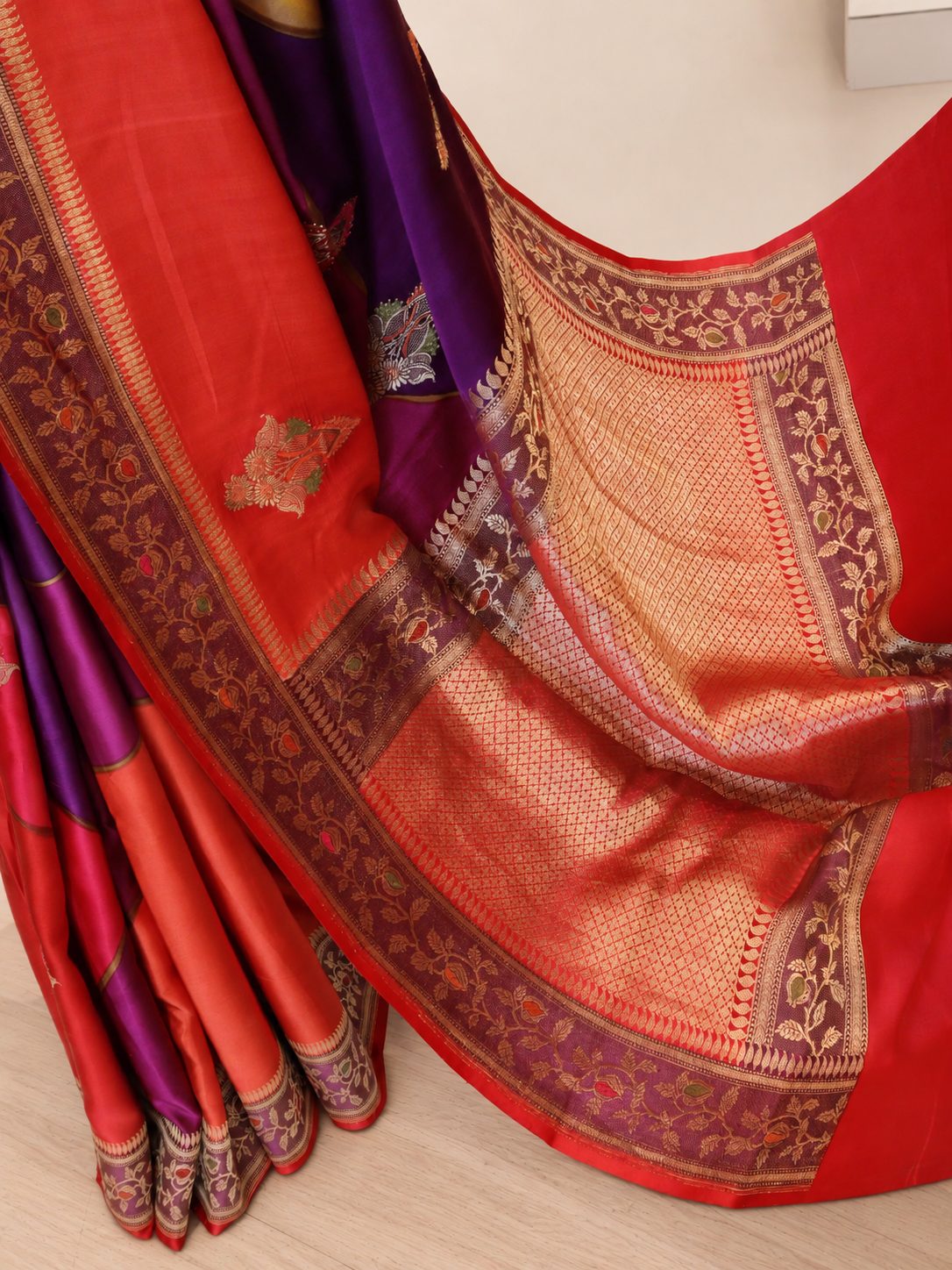 Wine magenta with contrasting red, orange and pink sections, highlighted by gold-toned zari. Katan Silk Banarasi saree texture detail
