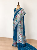 Teal blue with silver-toned zari and pink, peach, green and teal detailing. Tussar Silk Banarasi saree front drape view