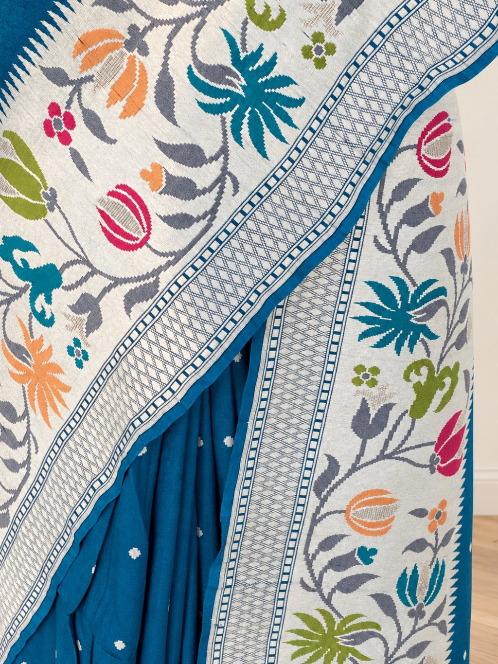 Teal blue with silver-toned zari and pink, peach, green and teal detailing. Tussar Silk Banarasi saree front drape view