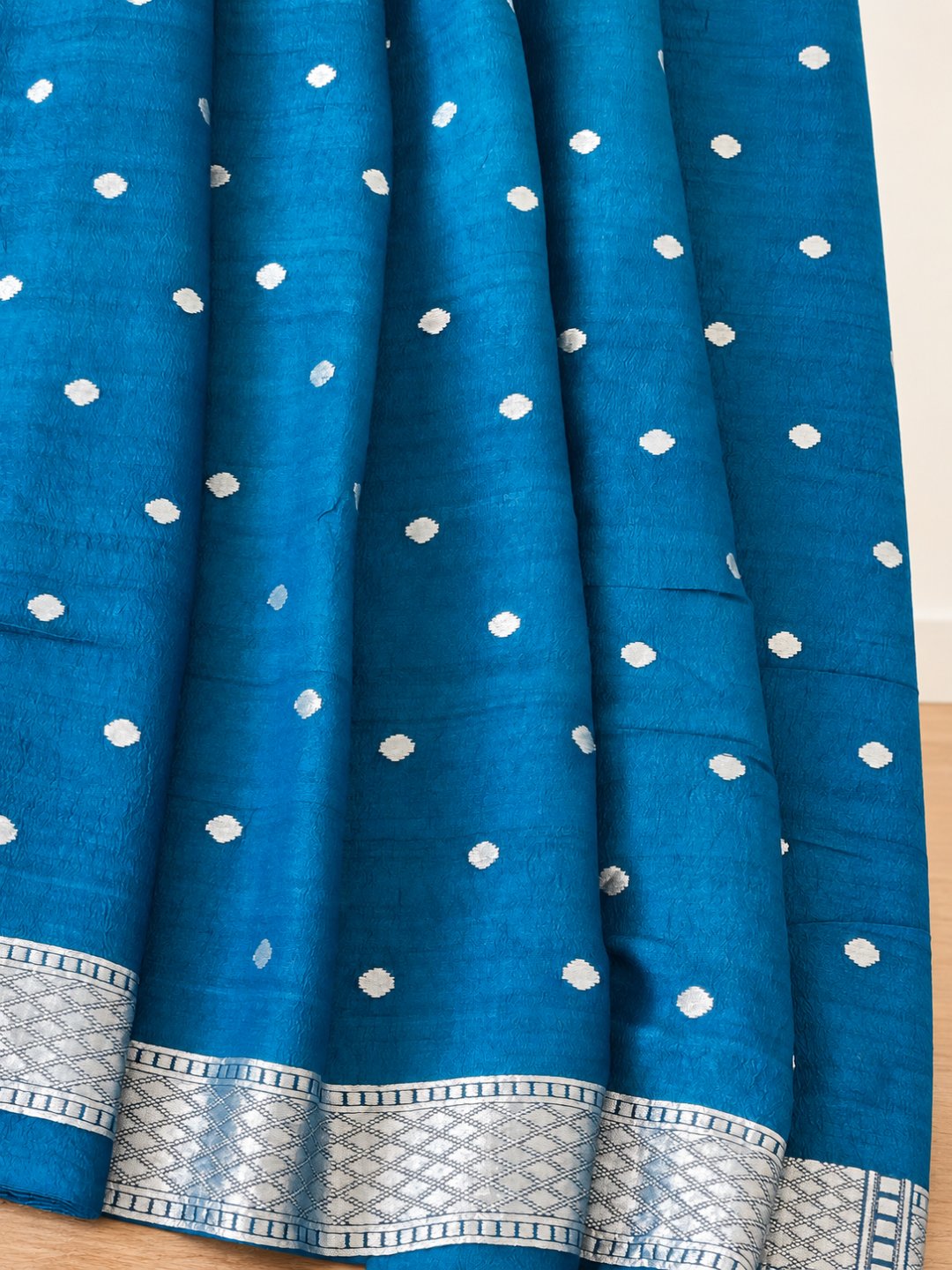 Teal blue with silver-toned zari and pink, peach, green and teal detailing. Tussar Silk Banarasi saree front drape view