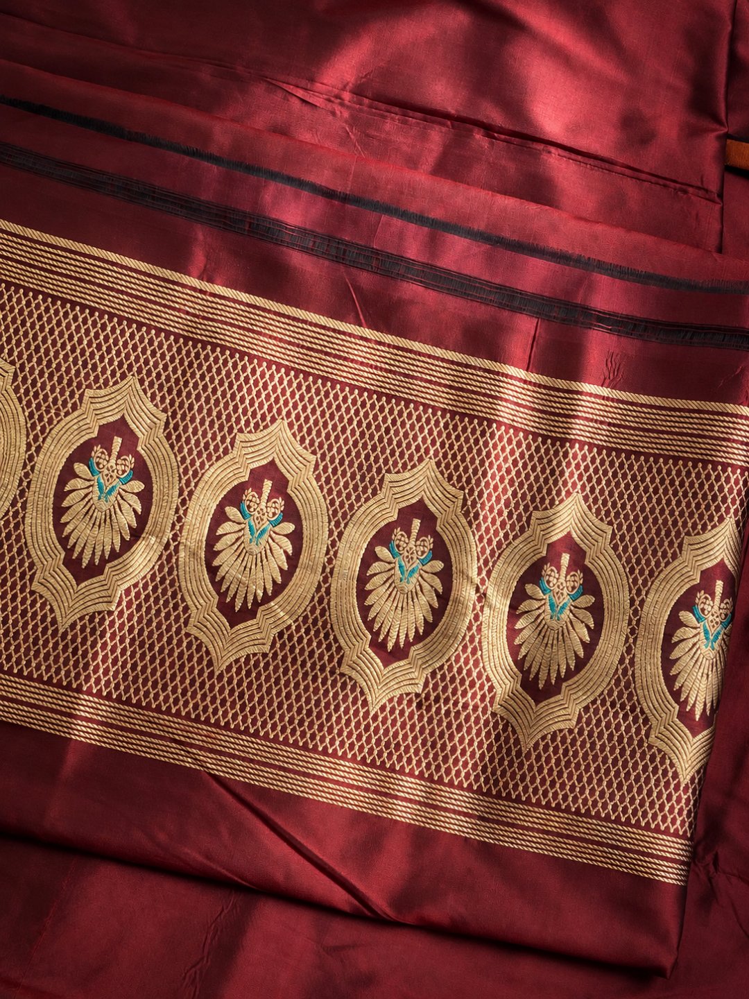 Burgundy with gold and small turquoise details Katan Silk Banarasi suit bottom detail