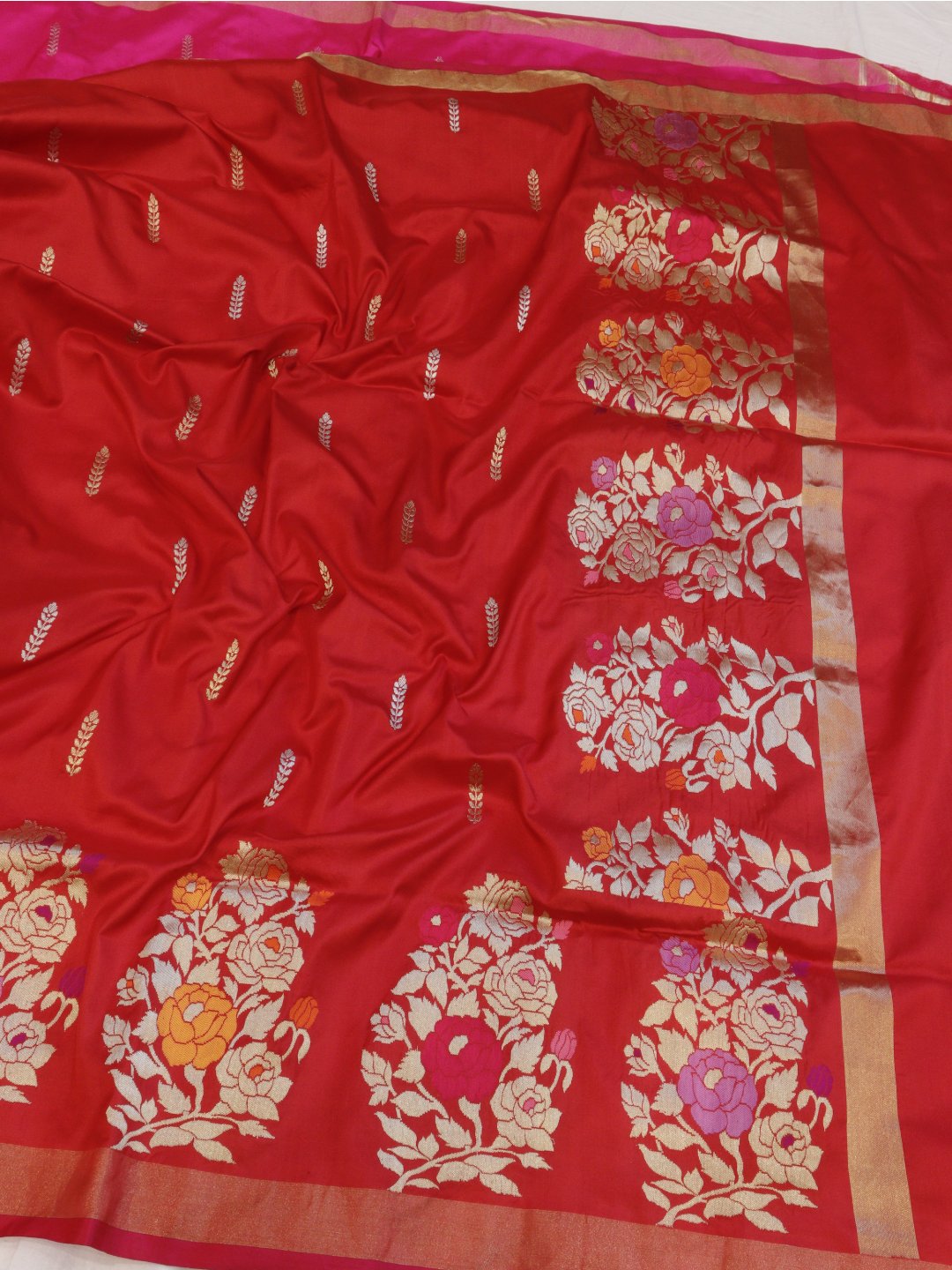 Red with a contrasting rani pink edge and gold-toned zari Katan Silk Banarasi saree border closeup