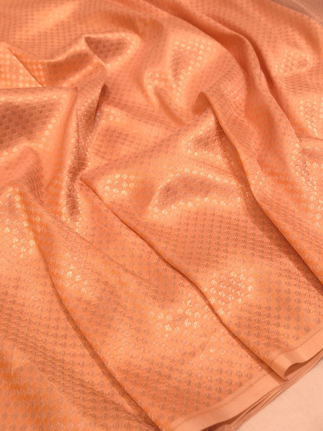 A muted lavender-grey base with peach, orange and gold-toned Mulbari Silk Banarasi saree folded view