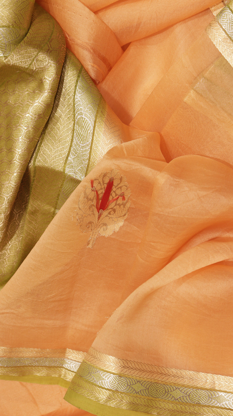 Close-up of peach-colored fabric with gold and green accents