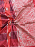 The combination of bold checks and delicate floral weaving gives this saree a…
